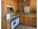 A kitchen showcases wood cabinets, laminate counters, and appliances, needing renovation at 317 29Th Ave. N, North Myrtle Beach, SC 29582
