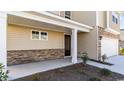 Inviting front porch showcasing stone accents, a stained front door, and neutral siding at 434 Clear Lake Dr., Conway, SC 29526