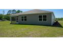 Spacious backyard with green grass and large windows showcasing the home's natural light at 4488 East Coast Ln., Shallotte, NC 28470