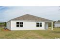 Exterior shot of the home showing the vinyl siding and expansive backyard with green grass at 4496 East Coast Ln., Shallotte, NC 28470