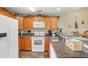 Well-lit kitchen featuring wood cabinetry, white appliances, and a breakfast bar with seating at 4567 Eastport Blvd. # 3P, Little River, SC 29566