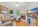 Cozy living room with comfortable seating, a ceiling fan, a balcony, and a large television at 4567 Eastport Blvd. # 3P, Little River, SC 29566
