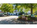 Exterior shot of the condo with lush landscaping and a parking area surrounded by mature trees at 4601 Greenbriar Dr. # 201, Little River, SC 29566