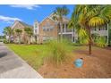 Brick condo exterior featuring lush landscaping, a screened patio, and mature palm trees at 4648 Fringetree Dr. # C, Murrells Inlet, SC 29576