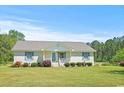 Charming single-story brick home featuring a welcoming front porch and well-manicured landscaping at 4684 Bluff Rd., Mullins, SC 29574
