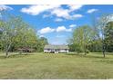 A picturesque front yard with mature trees framing a lovely single-story home on a sunny day at 4684 Bluff Rd., Mullins, SC 29574