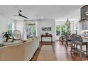 Bright living room featuring a ceiling fan, hardwood floors, and large windows at 48 Half Shell Ct., Litchfield, SC 29585