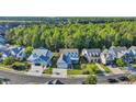 A picturesque aerial shot showcases a neighborhood with manicured lawns and a lush green forest backdrop at 5049 Middleton View Dr., Myrtle Beach, SC 29579