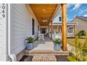 Inviting front porch with wood columns, ceiling fan, cozy seating, and brick steps leading to the entry at 5049 Middleton View Dr., Myrtle Beach, SC 29579