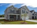 Charming two-story home with gray siding, a two-car garage, and a well-maintained front lawn in a suburban neighborhood at 6059 Forest Dell Ct, Myrtle Beach, SC 29579