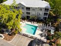 Aerial view of a condominium pool surrounded by lounge chairs and manicured landscaping at 70 Mingo Dr. # 3-E, Pawleys Island, SC 29585