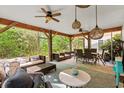 Spacious screened porch with ceiling fans, wicker furniture, and outdoor dining area at 77 Weatherboard Ct., Pawleys Island, SC 29585