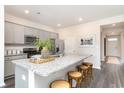 Kitchen island with speckled granite countertops, gray cabinets, seating for four, and modern appliances at 882 Farmers Passage Loop, Loris, SC 29569
