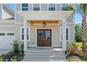 A welcoming covered front porch featuring beautiful wood columns and a mahogany double-door entry at 968 Shipmaster Ave., Myrtle Beach, SC 29579