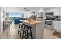 Bright kitchen with white cabinets, butcher block island, stainless appliances, and an open view to the living area at 1012 N Waccamaw Dr. # 507, Murrells Inlet, SC 29576