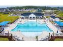 Aerial view of a resort-style pool with lounge chairs, palm trees, and a clubhouse for resident relaxation at 1091 Laconic Dr., Myrtle Beach, SC 29588