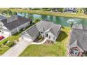 Aerial view of a well-kept home near a serene pond with a fountain, showcasing its desirable neighborhood location at 121 Ashworth Dr., Little River, SC 29566