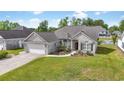 Beautiful single-story house boasts an attached garage, manicured lawn, and scenic water feature in a desirable community at 121 Ashworth Dr., Little River, SC 29566
