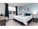 Serene main bedroom featuring a large window, plush carpet, and soothing blue accent wall at 1415 Nokota Dr., Conway, SC 29526