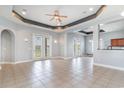 Spacious living room with tile flooring, a tray ceiling, and access to the backyard through French doors at 197 Northside Dr., Little River, SC 29566