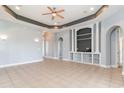 Bright, open living room featuring stylish built-ins, tray ceiling, and tile flooring at 197 Northside Dr., Little River, SC 29566