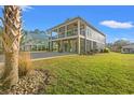 Coastal-style elevated home with a double front porch and lush green lawn at 355 Oak Ave., Murrells Inlet, SC 29576