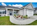 Inviting front yard features a beautifully landscaped garden with colorful flowers and decorative lighting leading to the front door at 377 Copperwood Loop, Conway, SC 29526
