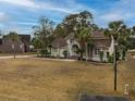 Beautiful home with palm trees, landscaped yard, and charming architecture at 4593 Lake Circle, Little River, SC 29566