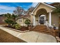 Inviting front entrance featuring a beautiful archway and landscaped garden at 4593 Lake Circle, Little River, SC 29566