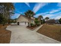 Spacious garage with an ample driveway surrounded by lush landscaping at 4593 Lake Circle, Little River, SC 29566