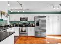 Bright kitchen with stainless steel appliances, white cabinets, and a green accent wall at 4755 Lightkeepers Way # 15-E, Little River, SC 29566