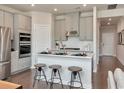 Modern kitchen features gray cabinets, stainless steel appliances, an island with stool seating and hardwood floors at 5060 Riverton Ct, Myrtle Beach, SC 29579