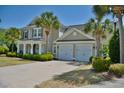 Beautiful home with an attached two-car garage, a cozy front porch, mature landscaping, and a wide driveway at 546 Olde Mill Dr., North Myrtle Beach, SC 29582