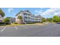 Condominium building exterior featuring multi-level balconies, parking and well-maintained green spaces at 5750 Oyster Catcher Dr. # 234, North Myrtle Beach, SC 29582