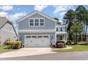 Two-story home with a two-car garage, manicured landscaping, and sidewalk to the front door at 600 Waterbridge Blvd., Myrtle Beach, SC 29579