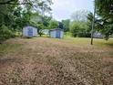 Expansive backyard featuring two storage sheds and lush greenery, perfect for outdoor activities at 721 French Collins Rd., Conway, SC 29526