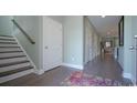 Inviting entryway with hardwood floors and staircase, featuring a colorful rug and neutral paint at 736 Choctaw Dr., Conway, SC 29526