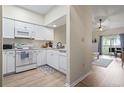 Bright kitchen featuring white appliances, light cabinets and an open view to the living area and lanai at 102 Scotch Broom Dr. # 302-B, Little River, SC 29566