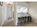 This kitchenette features white cabinets, black bar stools, and a light fixture with a unique design at 102 Scotch Broom Dr. # 302-B, Little River, SC 29566
