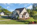 Aerial shot of a well-maintained home with beautiful lawn, colorful flowerbeds, and mature trees at 107 Long Bay Golf Pl., Longs, SC 29568