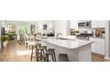 Open concept kitchen with granite countertops, stainless steel appliances, and breakfast bar overlooking living area at 1154 Silver Perch Place, Sunset Beach, NC 28468