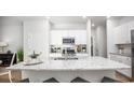 Bright kitchen boasts a large center island with seating, granite counters, and modern stainless steel appliances at 1154 Silver Perch Place, Sunset Beach, NC 28468