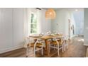 Inviting dining room with natural light, a rustic wood table, and decorative wicker pendant lighting at 1166 Silver Perch Place, Sunset Beach, NC 28468