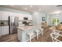 Modern kitchen with a large granite island, stainless steel appliances, and stylish bar stool seating for casual dining at 1166 Silver Perch Place, Sunset Beach, NC 28468