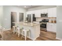 Bright kitchen featuring a granite island with bar stools, stainless steel appliances, and ample white cabinetry at 1166 Silver Perch Place, Sunset Beach, NC 28468