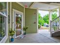 Charming condo entrance featuring a decorative wreath, welcome mat, and flowering plants at 128 Puffin Dr. # 1E, Pawleys Island, SC 29585