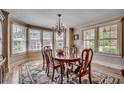 Bright dining room with large windows, chandelier, wood table and chairs, and stylish rug at 141 N Gate Rd., Myrtle Beach, SC 29572