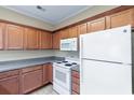 This kitchen features wood cabinets, an electric range, tile flooring, and a refrigerator at 148 Scotch Broom Dr. # 201, Little River, SC 29566