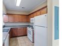 This kitchen features wood cabinets, an electric range, tile flooring, and a refrigerator at 148 Scotch Broom Dr. # 201, Little River, SC 29566