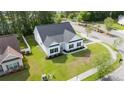 Aerial view of a white home with a dark roof and a lush green lawn in a neighborhood setting at 1500 Sunmeadow Dr., Conway, SC 29526